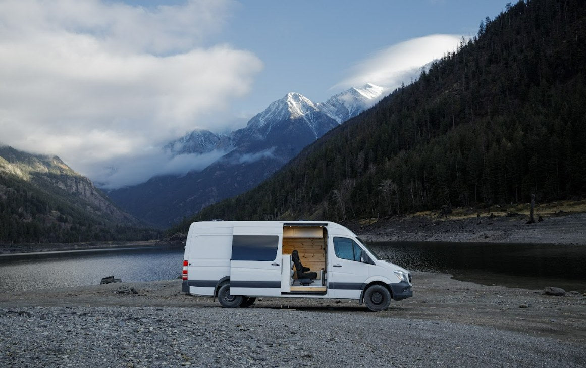  ready for adventure.|RV rental adventure! A white camper van with an open side door on a rocky lake shore — photo 2