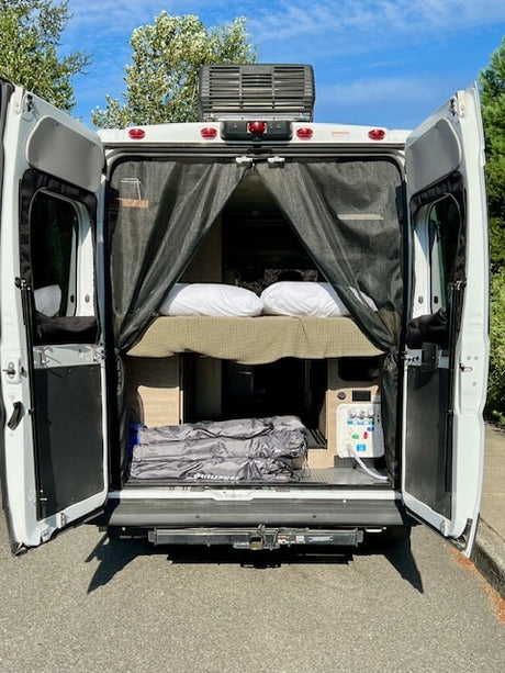 Spacious RV rental with a cozy bed, ample storage, and controls, perfect for your next road trip adventure.