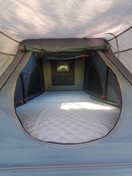 Spacious rooftop tent interior with quilted mattress, ideal for RV rental adventures.