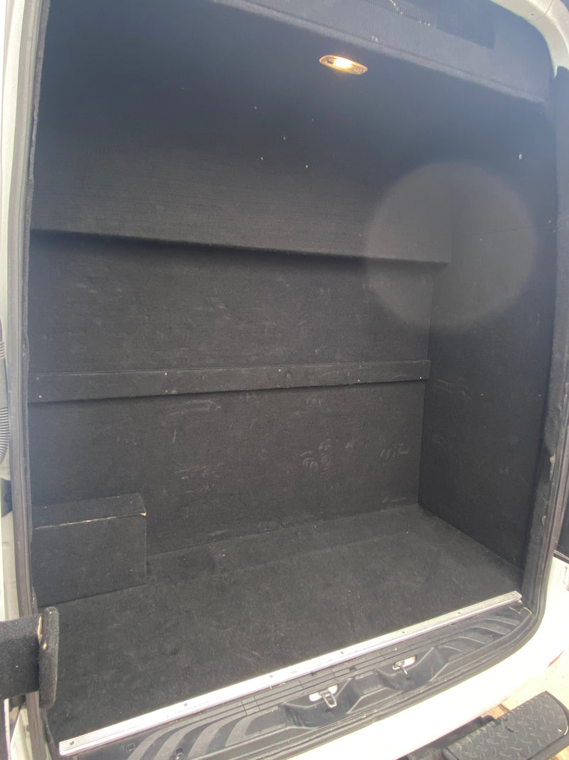 Inside a custom-built RV rental cargo van, featuring a black-lined storage area with built-in shelves and an overhead light. — photo 10