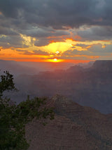 Vibrant sunset illuminates the vast Grand Canyon, casting a warm glow over its layered landscape. Ideal for your RV rental journey.