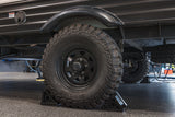 Rugged RV rental trailer with Westlake Mud Legend off-road tires, securely chocked for stability.