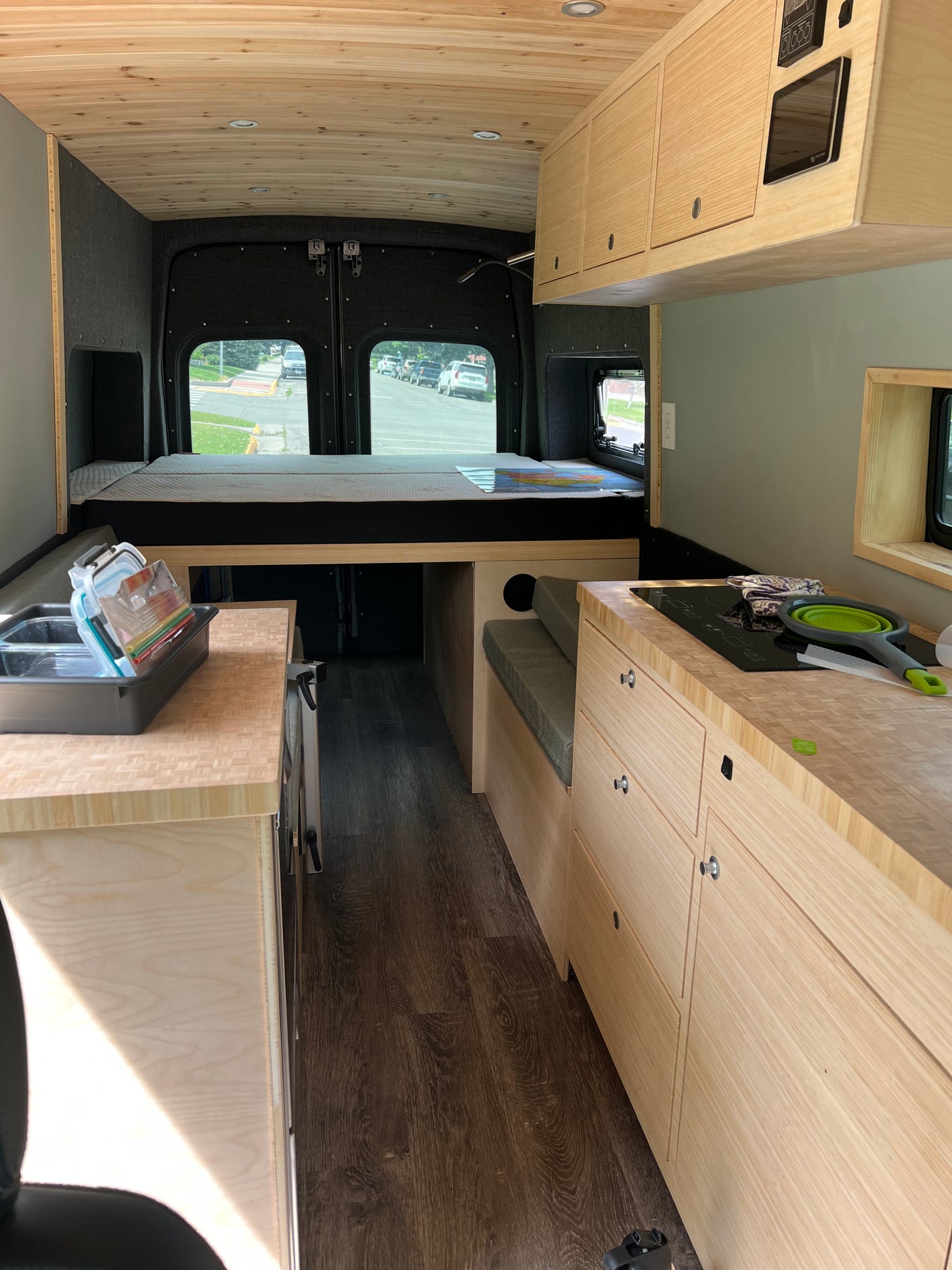 Spacious and modern rv rental interior with custom wood features, comfy bed, and full kitchen for mobile living.