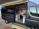 Explore this modern rv rental: an Entegra Ethos camper van's open interior with a kitchen and lighted awning.