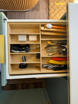 Organized kitchen drawer in an RV rental, filled with utensils, chargers, and knives, optimizing compact space.