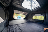Inside a comfy rooftop tent with a quilted mattress. Enjoy the campground view on your next RV rental adventure!