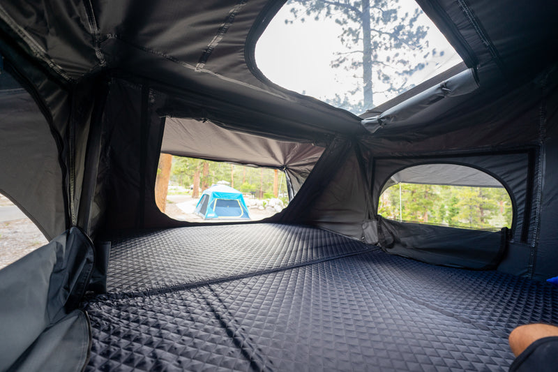 Inside a comfy rooftop tent with a quilted mattress. Enjoy the campground view on your next RV rental adventure! — photo 4