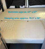 RV rental interior bed with mattress (67"x57") & sleeping area (70.5"x58") dimensions, showing convertible comfort.
