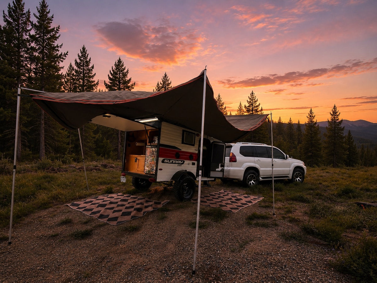 An RV rental dream: a white SUV tows a Sunray travel trailer, set up with an awning against a stunning sunset & pine forest. — photo 14