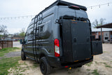 This rugged dark gray RV rental van is equipped with a roof rack, side ladder, and rear-mounted AVATAR storage boxes for mobile adventures.
