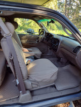 Spacious vehicle interior, ideal for an RV rental, showing tan seat covers, rubber floor mats, ready for outdoor trips.