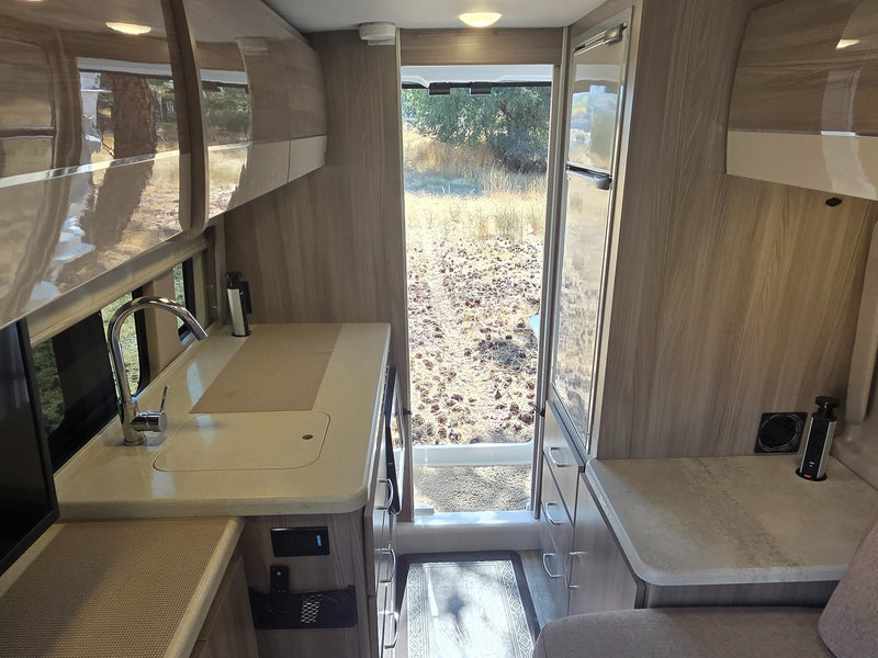  and overhead storage with outdoor views.|Modern rv rental interior with a comfy sofa — photo 9