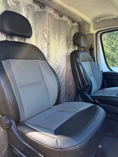 Interior of an RV rental van, featuring two-tone front seats and privacy curtains. Ready for adventure or a comfortable drive.