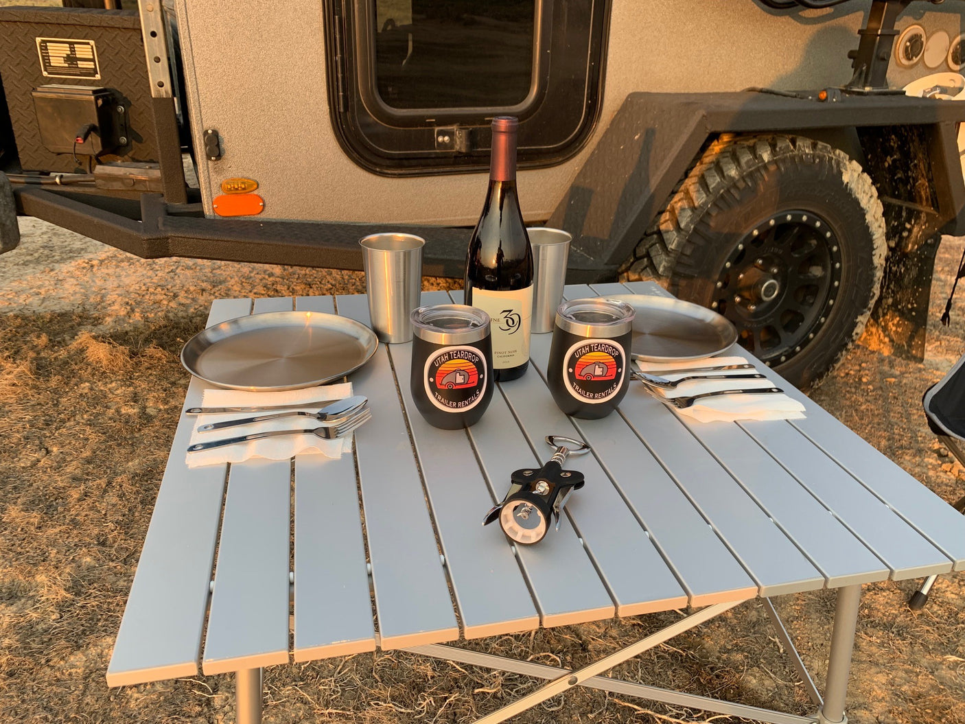 Enjoying an outdoor dinner set up next to an RV rental. Perfect for camping adventures with your Utah Teardrop trailer.