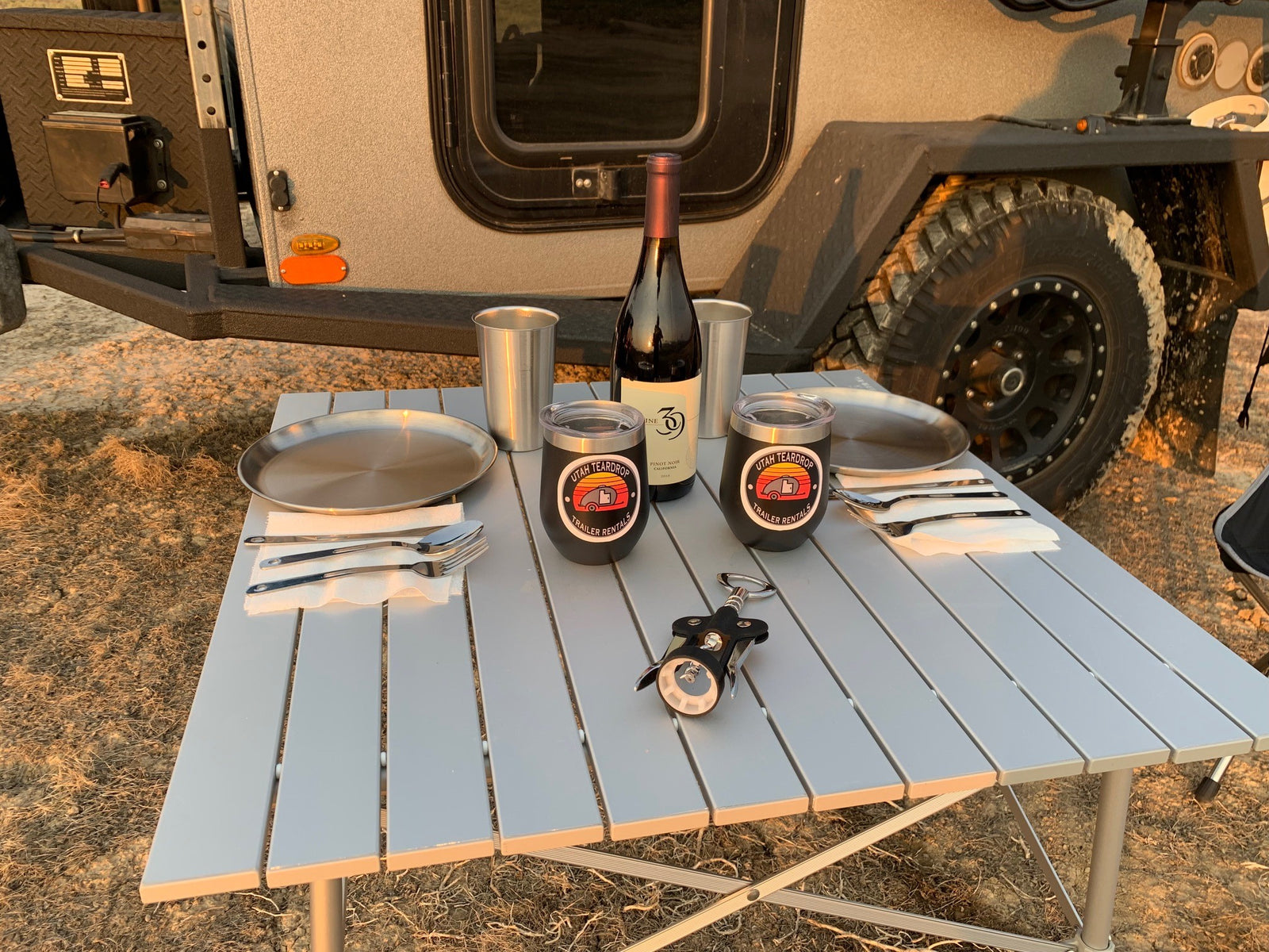 Enjoying an outdoor dinner set up next to an RV rental. Perfect for camping adventures with your Utah Teardrop trailer.