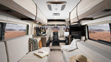 Explore the comfortable interior of this modern RV rental, perfect for desert adventures. Features spacious living, kitchenette, & scenic views.