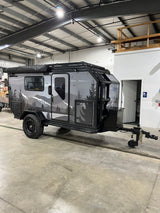 This rugged overland adventure trailer, perfect for RV rental, features a mountain graphic and robust off-road tires.