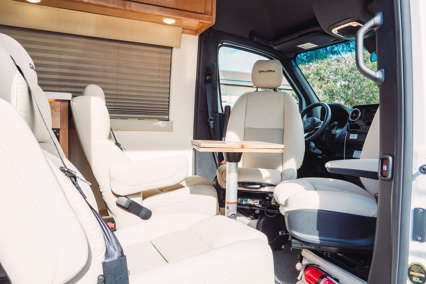 Experience comfort in this luxury RV rental. Features plush cream seating, a portable table, and a clean, inviting interior. — photo 10