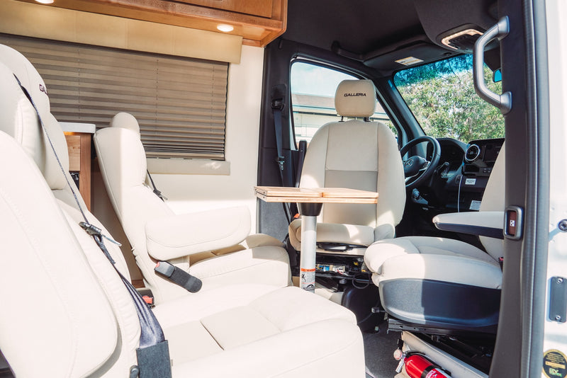 Experience comfort in this luxury RV rental. Features plush cream seating, a portable table, and a clean, inviting interior. — photo 10