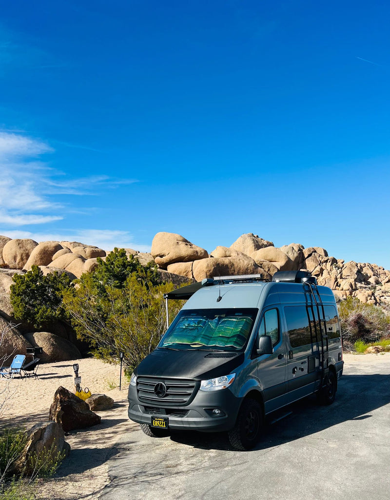  with a vivid pink & blue sunset over rocky hills.|RV rental for a desert escape: A blue campervan parked at twilight in Joshua Tree — photo 16