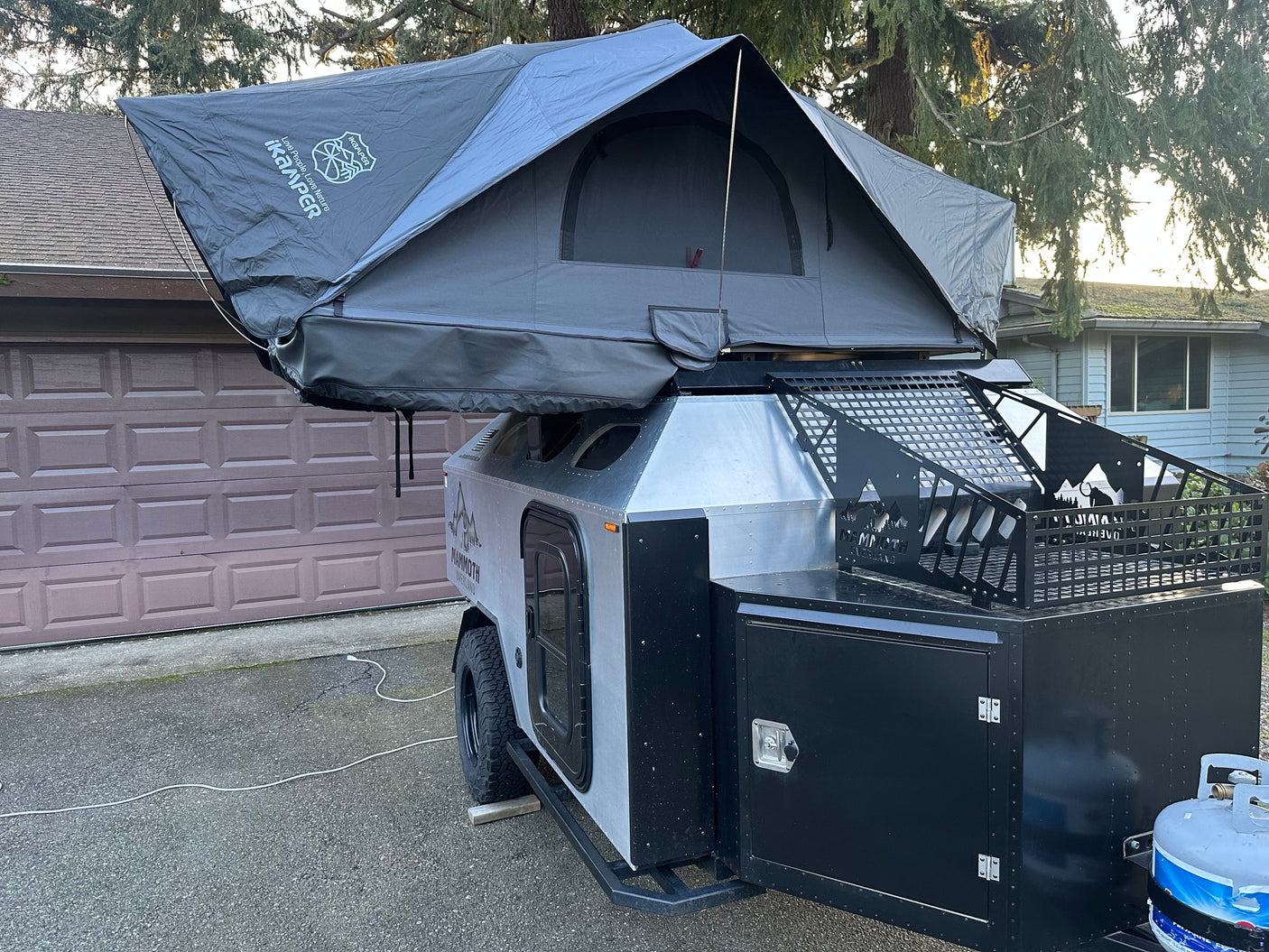 Modern overland trailer with a rooftop tent and gear storage, perfect for an RV rental adventure.