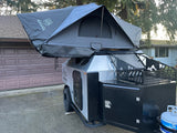 Modern overland trailer with a rooftop tent and gear storage, perfect for an RV rental adventure.
