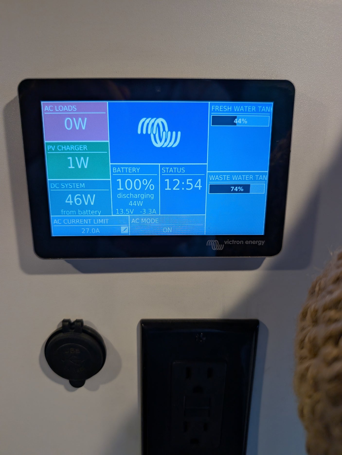 RV rental's Victron Energy panel shows 100% battery, 44% fresh water, 74% waste, and 46W DC power use.