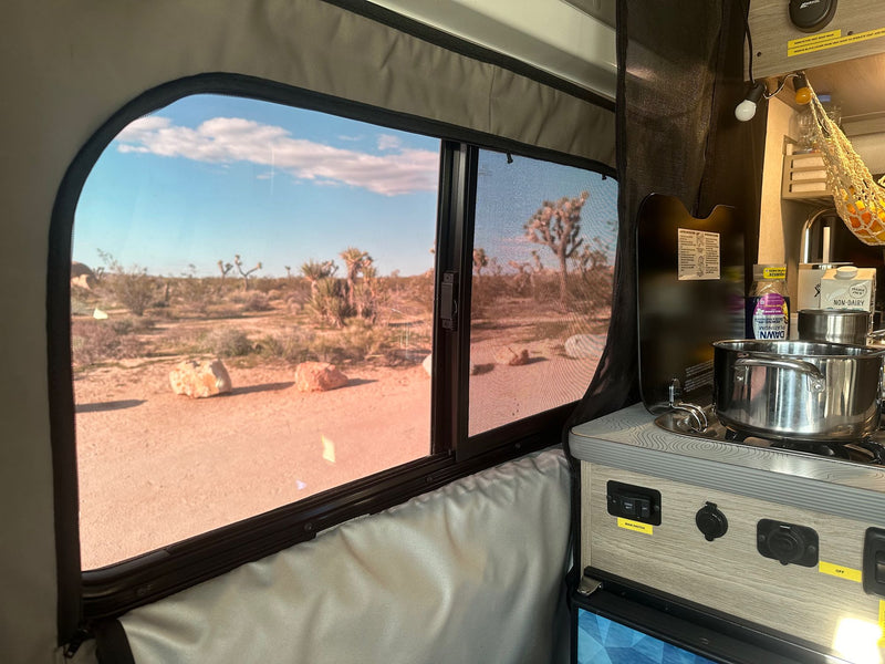  family outside enjoying the trip.|A white Winnebago camper van (RV) parked among massive — photo 9