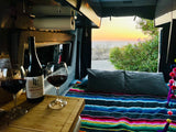 Experience an RV rental: a cozy bed, wine, and a breathtaking ocean sunset right from your camper van.