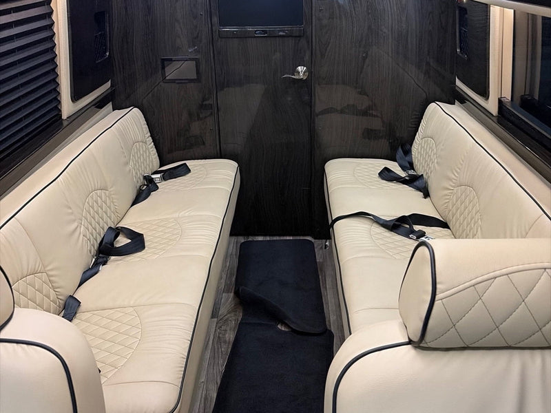 is parked in a lot with a cloudy sky reflected in its windows.|Comfortable rv rental interior: rows of beige leather seats — photo 3