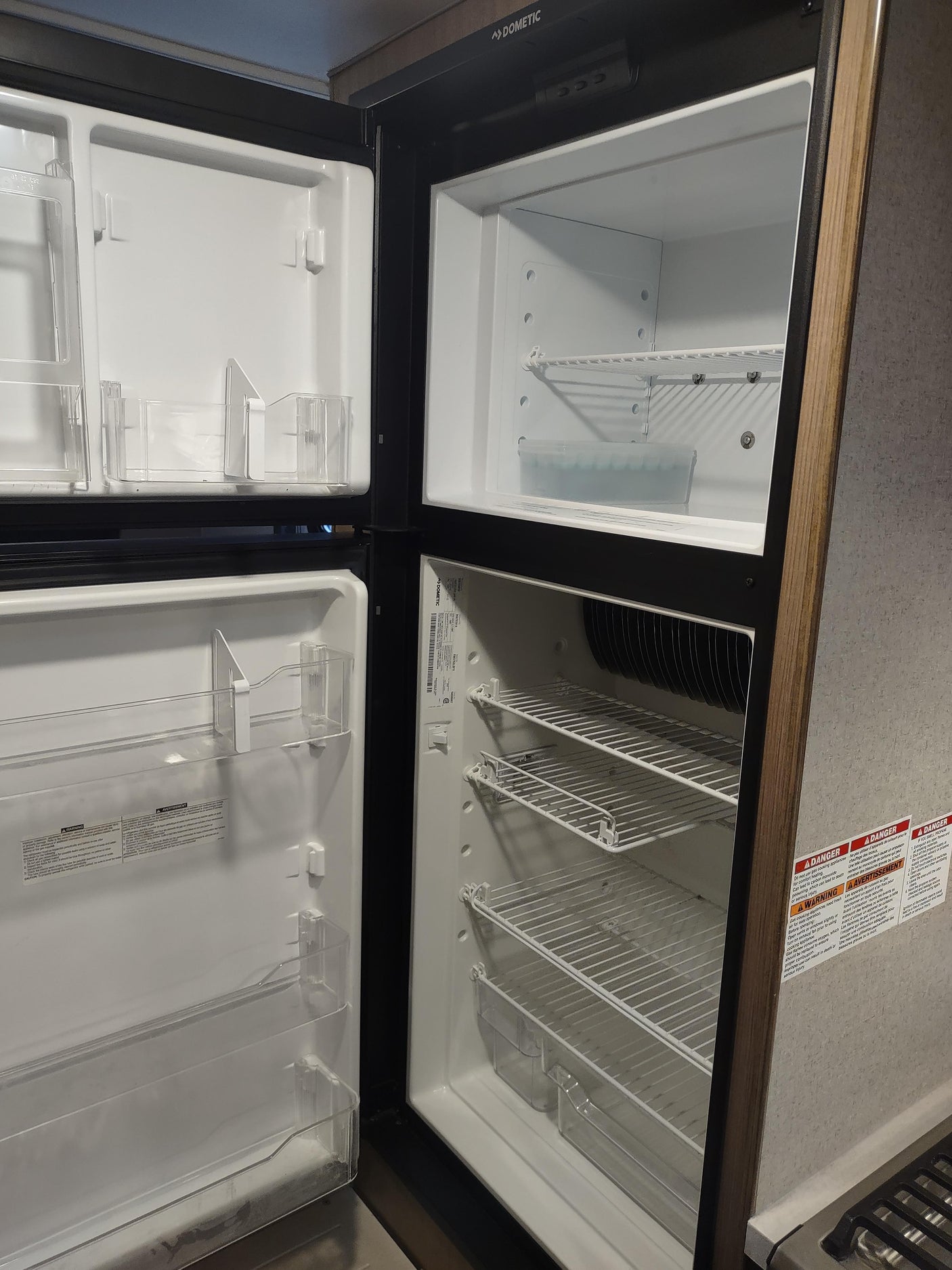 Clean, empty Dometic RV rental fridge and freezer interior, ready for use.