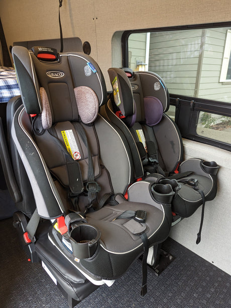 An RV rental's interior features two Graco child car seats, ensuring safe travels for families on the road.