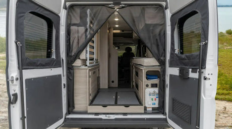 Explore a compact RV rental. Rear doors open to reveal a functional camper van interior with sleeping, kitchen, and storage.