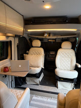 RV rental's inviting interior with swiveling front seats, a laptop workstation, and overhead amenities. A comfy mobile office.