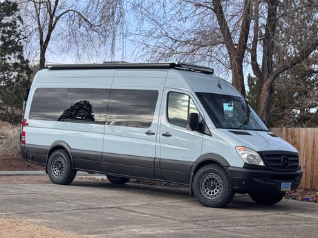 A light gray Mercedes Sprinter **RV rental** sits parked, an adventure-ready conversion van.