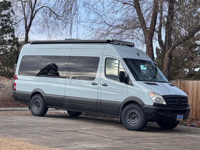 A light gray Mercedes Sprinter **RV rental** sits parked, an adventure-ready conversion van.