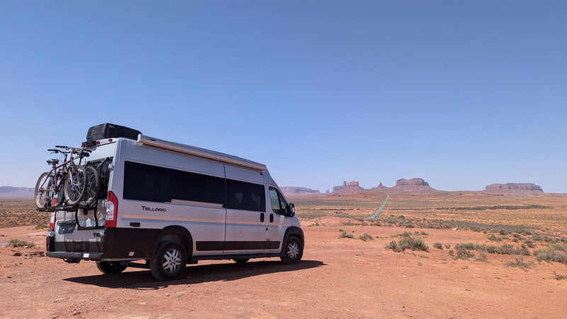 Silver RV rental camper van with bikes parked in Monument Valley — photo 1