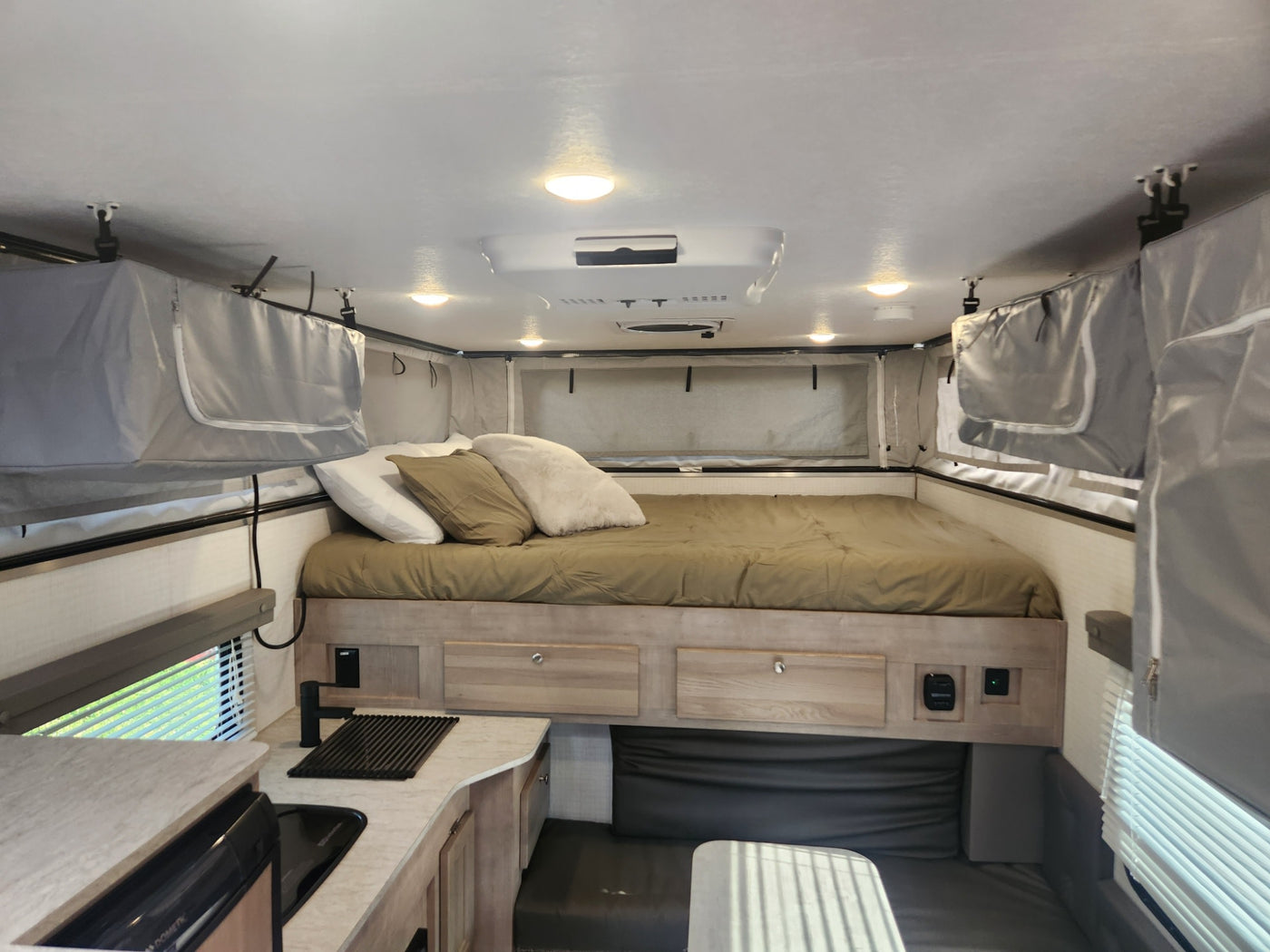  and lights. Perfect for an RV rental trip!|Inside an RV rental: a comfortable bedroom with a made bed — photo 3