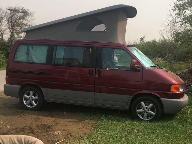 Red VW Eurovan pop-top RV rental van parked outdoors