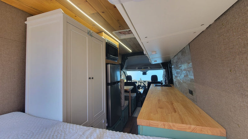  and open rear doors revealing a residential driveway view.|Inside this RV rental — photo 7