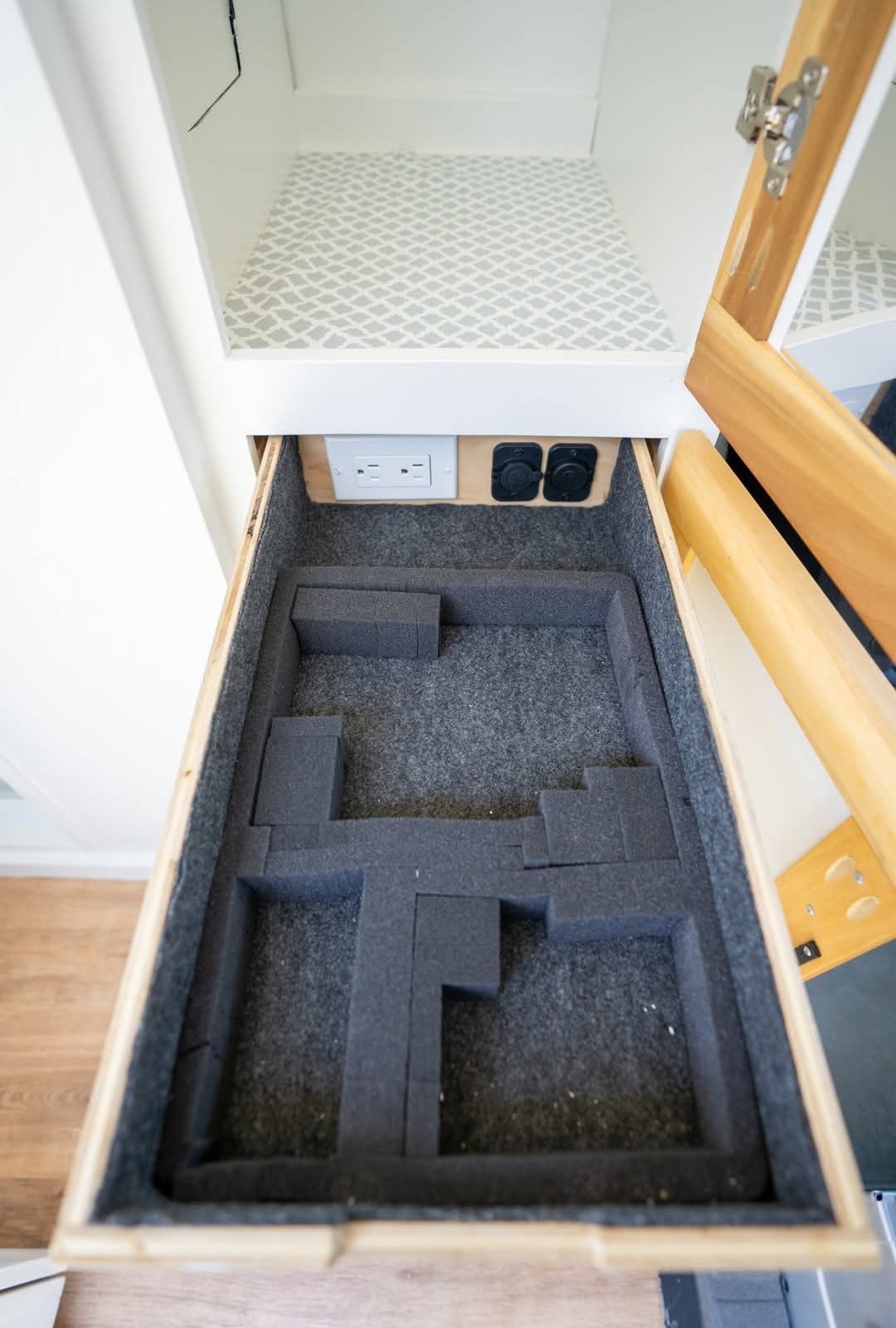Organized RV rental drawer with custom foam storage for gear and convenient power outlets above. — photo 14
