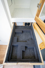 Organized RV rental drawer with custom foam storage for gear and convenient power outlets above.