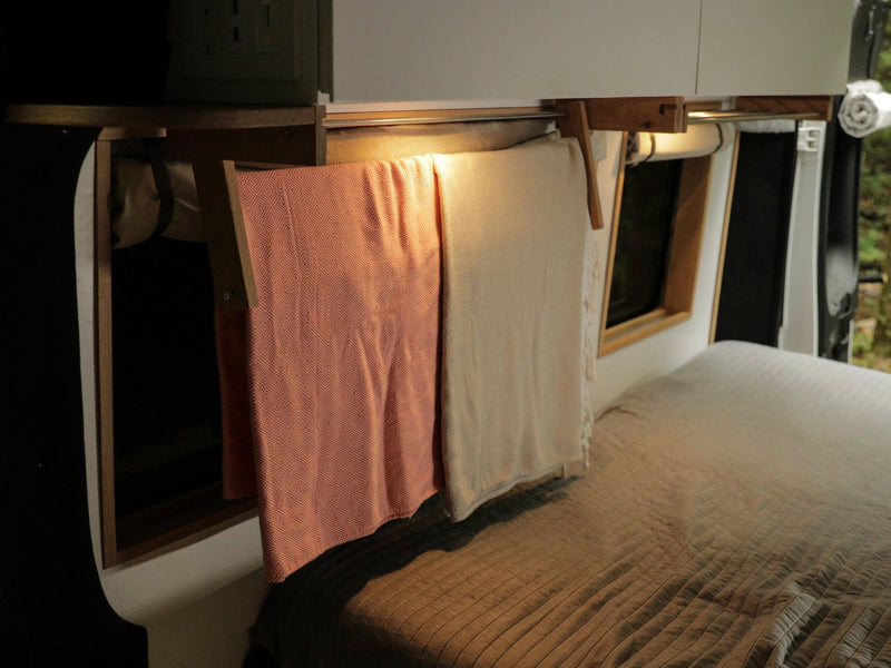  compact kitchen with stove and fridge on wooden floor. Forest views ahead.|Open Isotherm fridge in an RV rental — photo 17