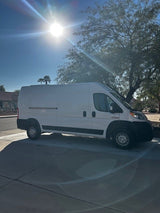 Bright white cargo van (Ram ProMaster) on a sunny driveway, ideal for an RV rental conversion.