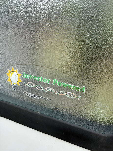 Sticker on an RV rental's textured window announces 'Inverter Powered' for general circuits, microwave, & A/C.