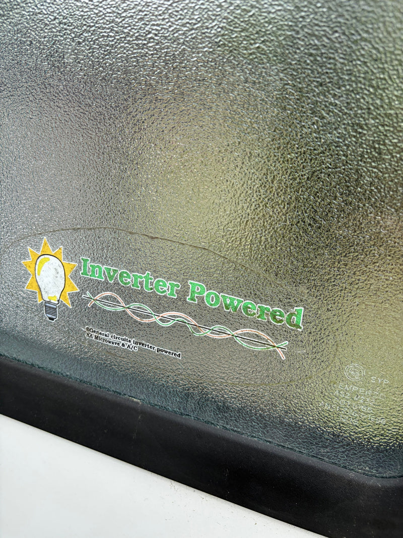 Sticker on an RV rental's textured window announces 'Inverter Powered' for general circuits, microwave, & A/C. — photo 3