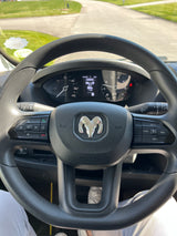 Driver's view inside an rv rental, showing the Ram steering wheel, dashboard with 405 mi trip, and the sunny road ahead.