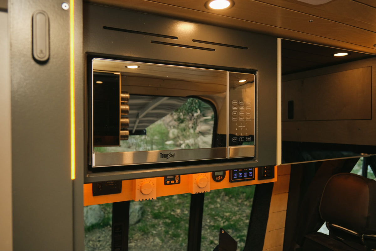  and a scenic view of a tree-filled campsite from the camper van.|RV rental with a seaside kitchen view: modern faucet — photo 9