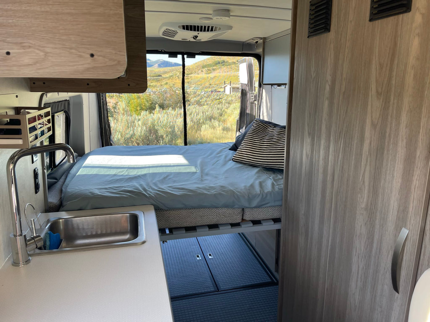  and comfortable quilted seats.|Cozy RV rental: compact kitchen with stove — photo 6