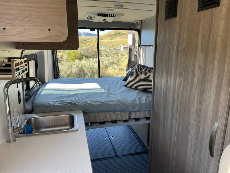  and comfortable quilted seats.|Cozy RV rental: compact kitchen with stove — photo 6